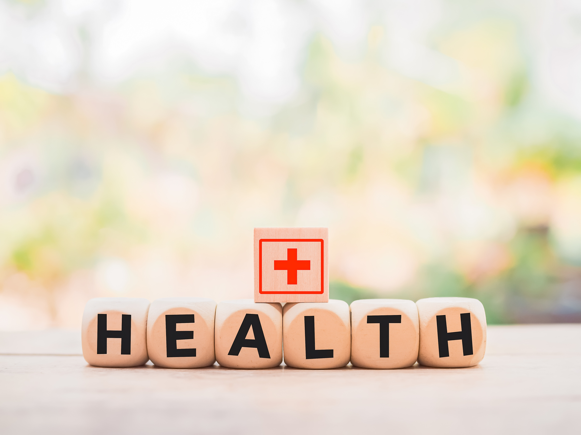 Wooden block with word HEALTH and health care or medical icon 